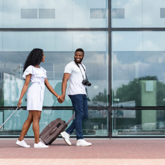 Going,To,Travel.,African,Couple,Walking,With,Luggage,Near,Airport